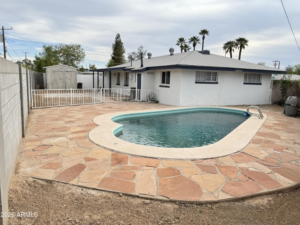 845 N Los Alamos Dr, Goodyear, AZ 85338 - view of swimming pool with a storage unit, a patio area, and a fenced backyard