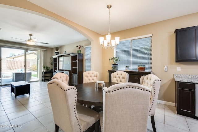 dining space featuring ceiling fan with notable chandelier and light tile patterned flooring