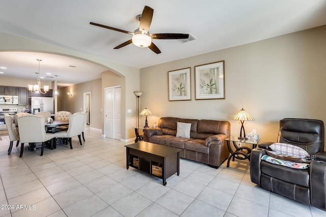 living room with ceiling fan with notable chandelier and light tile patterned floors