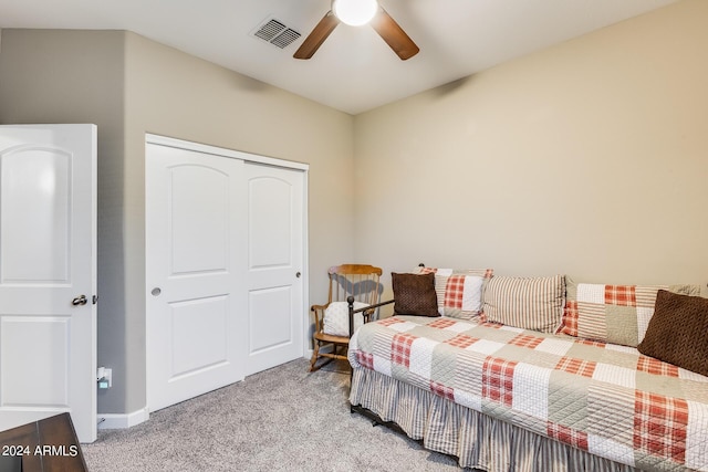 bedroom with ceiling fan, light carpet, and a closet