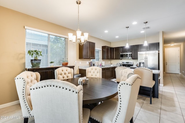 dining space with a notable chandelier, light tile patterned floors, and sink