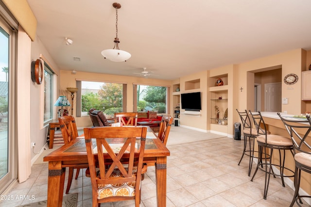 dining space with light tile patterned flooring, built in features, and ceiling fan