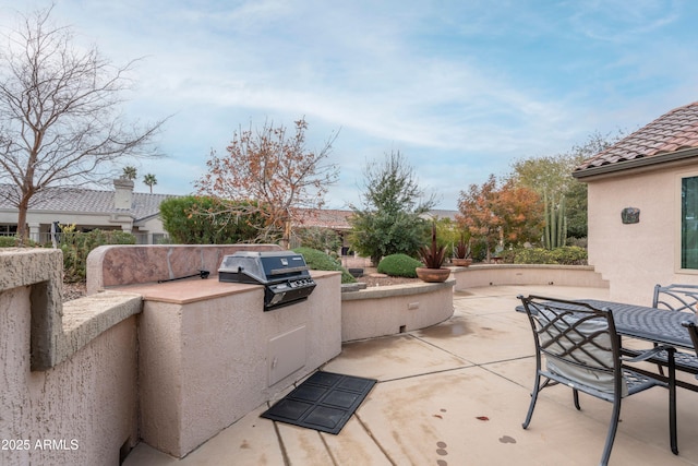 view of patio featuring an outdoor kitchen and a grill