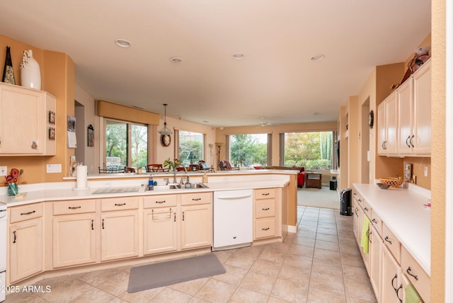 kitchen with light tile patterned flooring, sink, decorative light fixtures, dishwasher, and kitchen peninsula