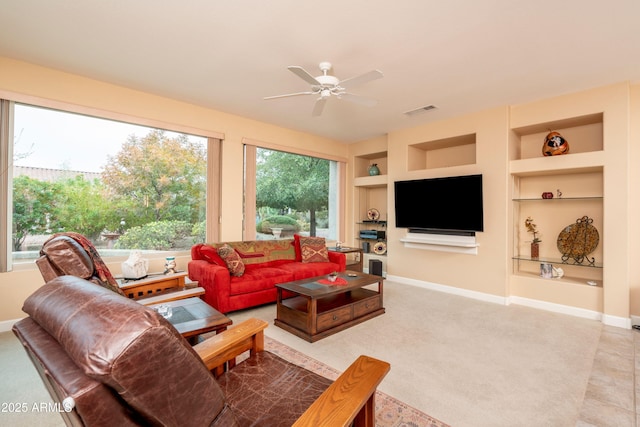 living room with built in shelves and ceiling fan