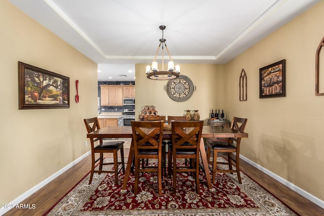 dining space with hardwood / wood-style flooring and an inviting chandelier