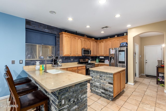 kitchen featuring sink, a center island, stainless steel appliances, tasteful backsplash, and kitchen peninsula