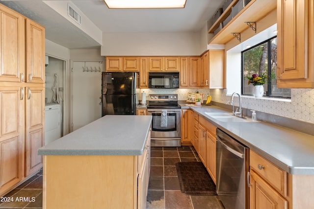 kitchen with sink, black appliances, washer / clothes dryer, a center island, and decorative backsplash