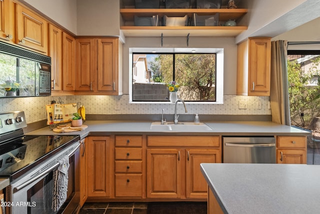 kitchen with a healthy amount of sunlight, decorative backsplash, sink, and stainless steel appliances