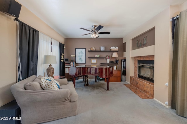 carpeted living room featuring a tiled fireplace and ceiling fan