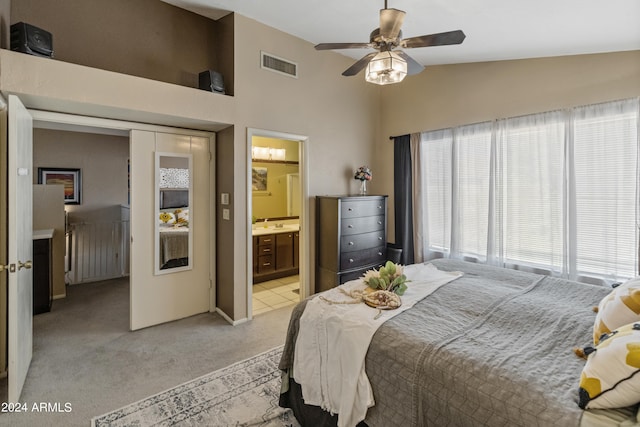 bedroom featuring light carpet, lofted ceiling, connected bathroom, and ceiling fan