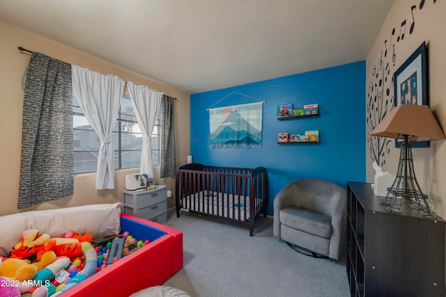 bedroom featuring a nursery area and carpet floors