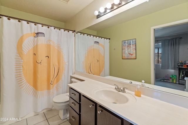 bathroom featuring tile patterned flooring, vanity, and toilet