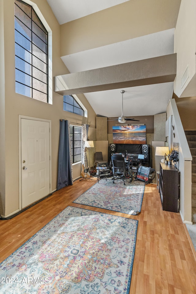 living room with light hardwood / wood-style flooring and a towering ceiling