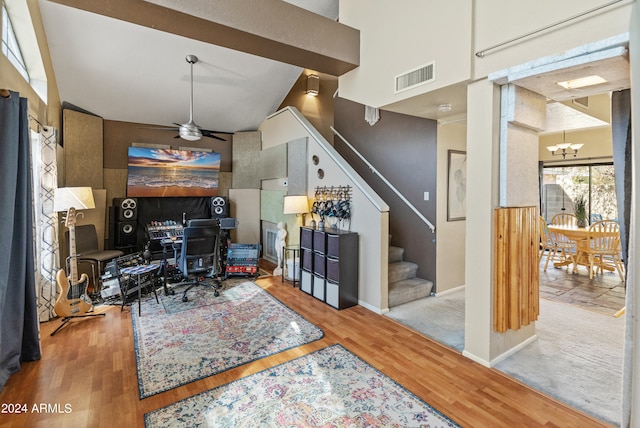 office area with ceiling fan with notable chandelier, light hardwood / wood-style flooring, and high vaulted ceiling