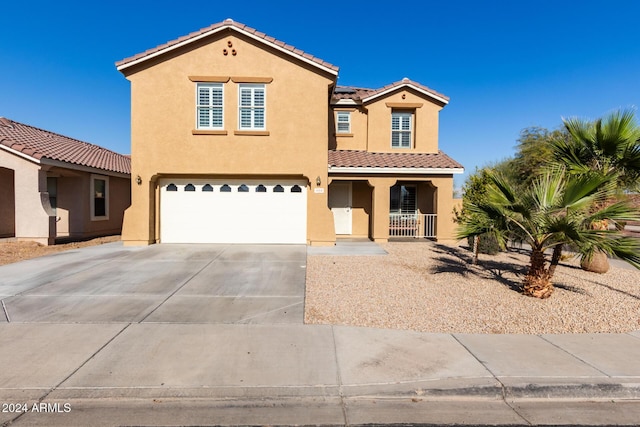 mediterranean / spanish home featuring a porch and a garage