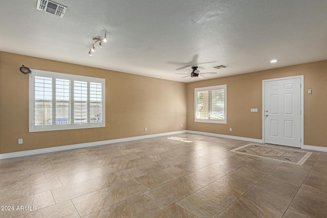 spare room featuring ceiling fan and a textured ceiling