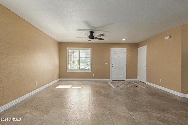 unfurnished room featuring ceiling fan and a textured ceiling