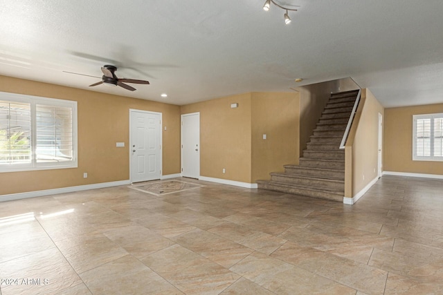 interior space featuring ceiling fan and a textured ceiling