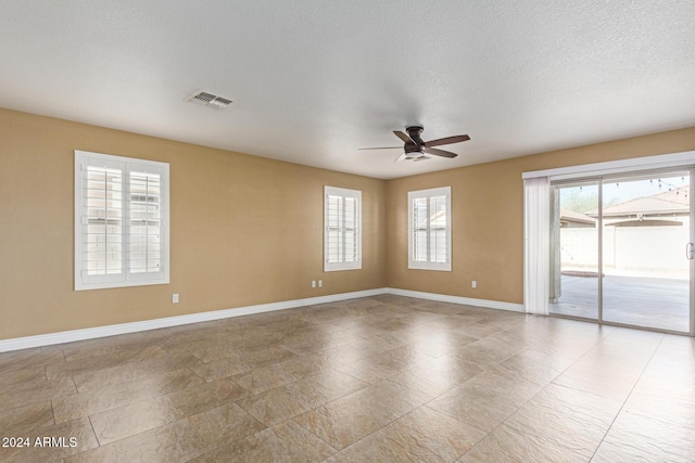 unfurnished room with a textured ceiling and ceiling fan