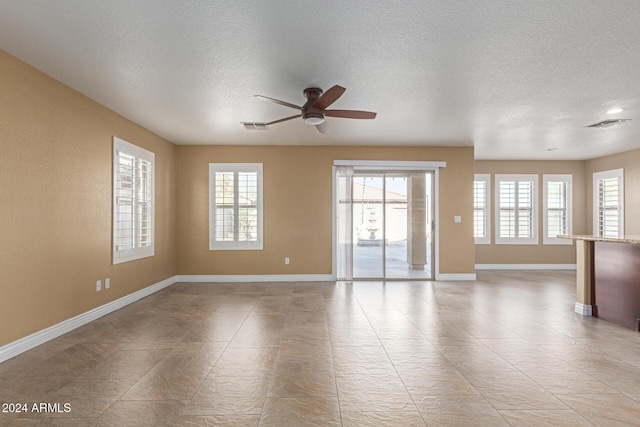 spare room featuring ceiling fan and a textured ceiling