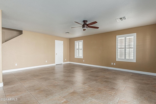 unfurnished room with a textured ceiling, a wealth of natural light, and ceiling fan