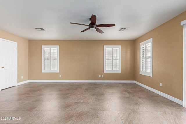 spare room with ceiling fan and a wealth of natural light