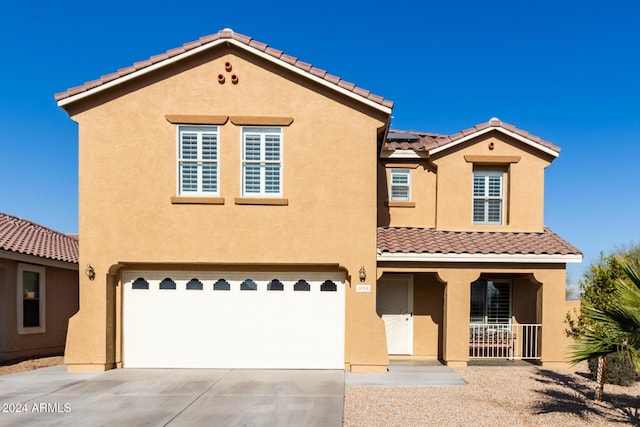 mediterranean / spanish house with covered porch and a garage