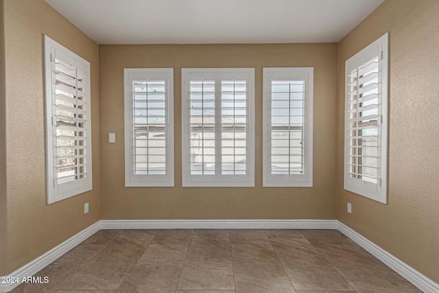 tiled spare room with a wealth of natural light