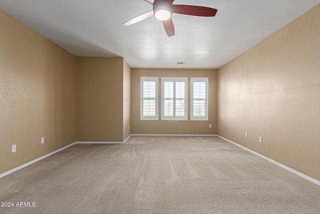 carpeted empty room featuring a textured ceiling and ceiling fan