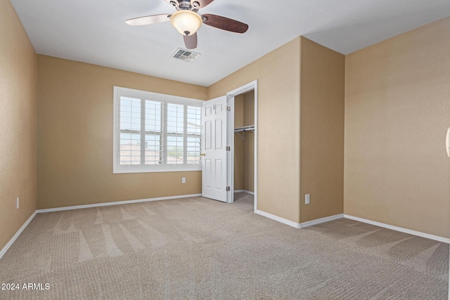 unfurnished bedroom with ceiling fan, a closet, and light colored carpet