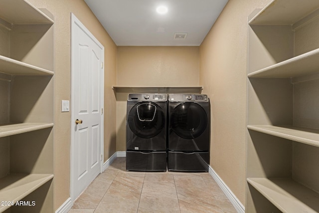 washroom with washer and dryer and light tile patterned floors