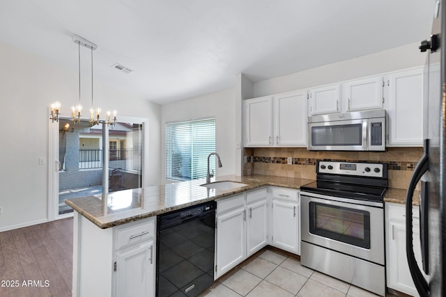 kitchen featuring stainless steel appliances, visible vents, white cabinets, a sink, and a peninsula