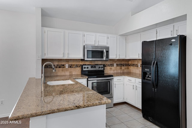 kitchen with stainless steel appliances, a peninsula, a sink, white cabinetry, and light stone countertops