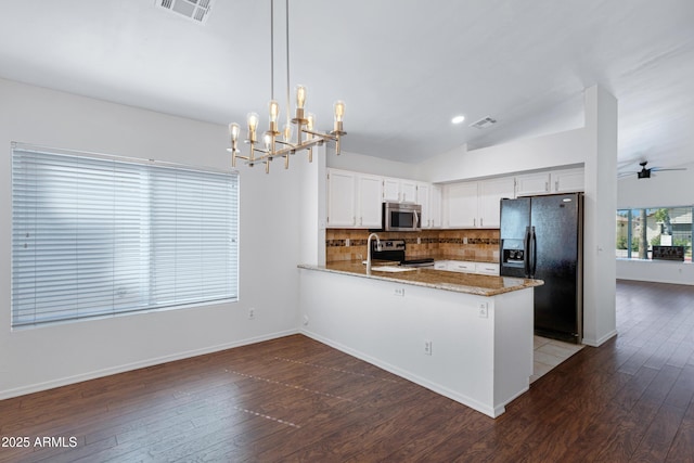 kitchen featuring tasteful backsplash, visible vents, dark wood-type flooring, a peninsula, and stainless steel appliances