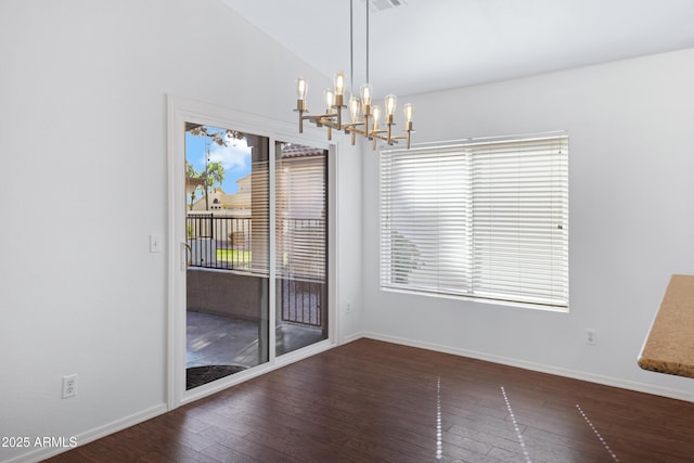 unfurnished dining area featuring vaulted ceiling, hardwood / wood-style flooring, a wealth of natural light, and baseboards