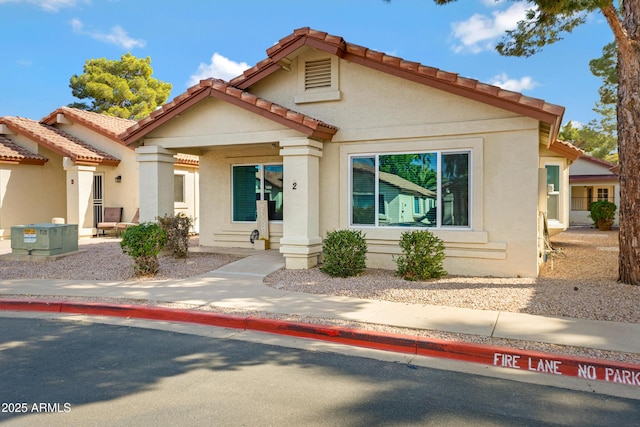 mediterranean / spanish-style house with a tiled roof and stucco siding