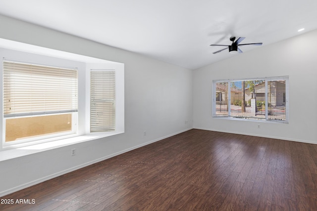 unfurnished room featuring lofted ceiling, hardwood / wood-style floors, a ceiling fan, and baseboards