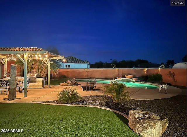 pool at night with a patio area, a fenced backyard, a fenced in pool, and a yard