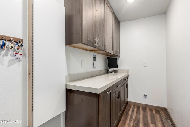 washroom with dark wood-style floors and baseboards