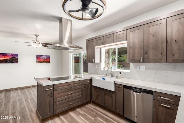 kitchen featuring a peninsula, ceiling fan, island range hood, and dishwasher