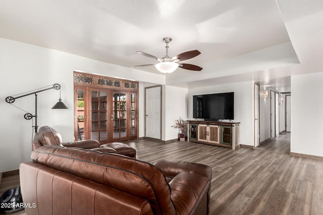 living area with baseboards, a ceiling fan, and wood finished floors