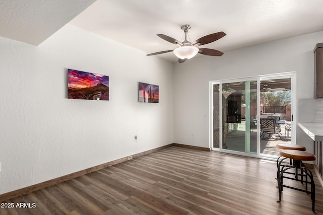 unfurnished room with a ceiling fan, baseboards, and wood finished floors