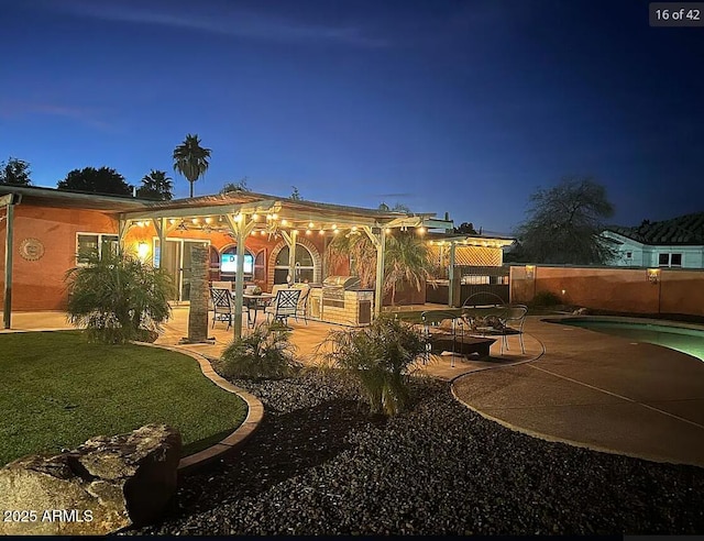 back of house at twilight featuring a patio area, fence, and a fenced in pool