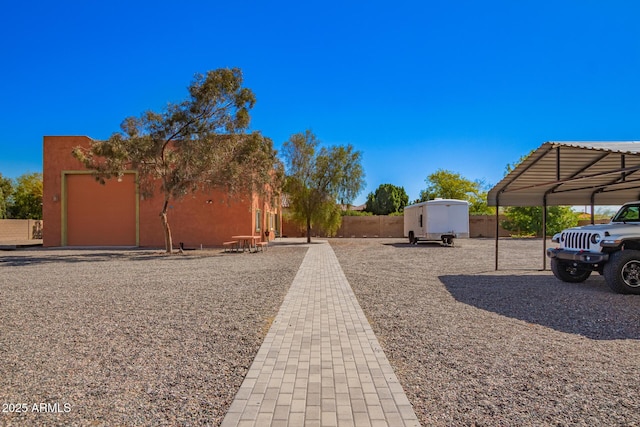 view of yard featuring a carport and fence