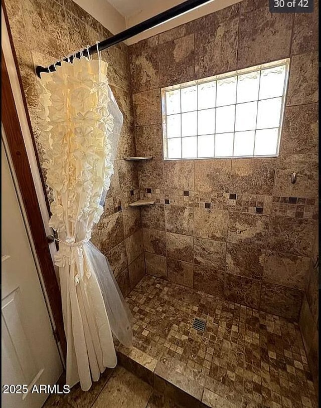 full bath featuring a tile shower