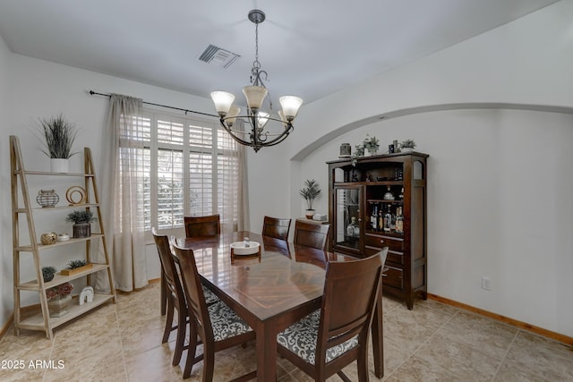 tiled dining space featuring an inviting chandelier