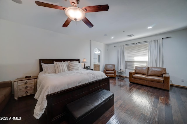 bedroom featuring ceiling fan, connected bathroom, and dark hardwood / wood-style flooring