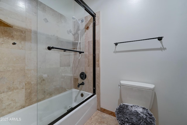 bathroom with toilet and combined bath / shower with glass door