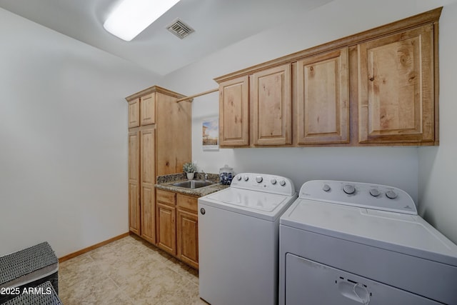 washroom featuring cabinets, sink, and washer and clothes dryer